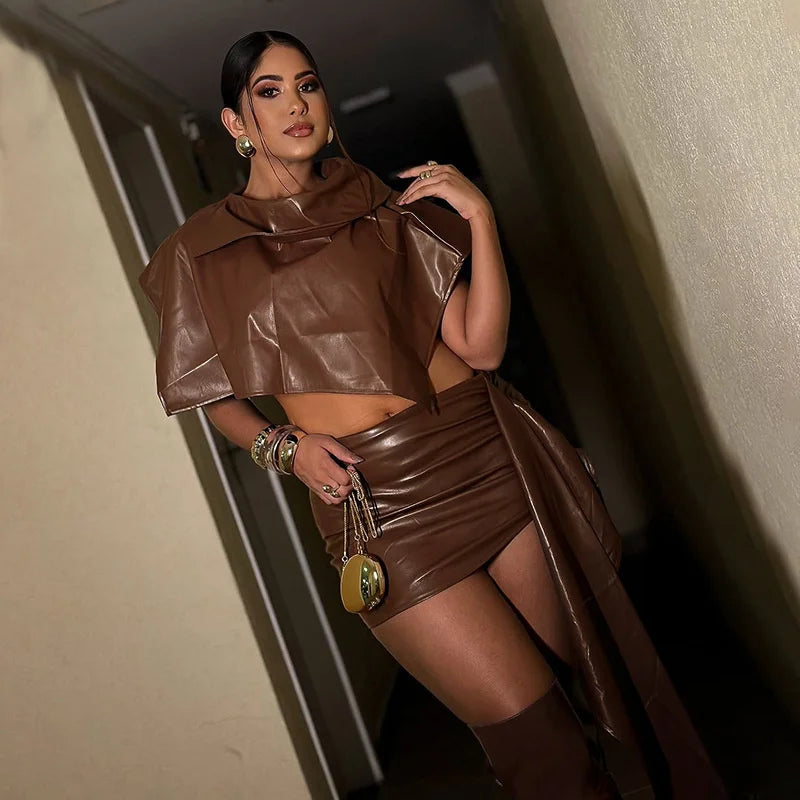 Woman wearing a brown leather outfit posing indoors.