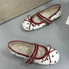 Pair of white polka dot ballet flats with red trim