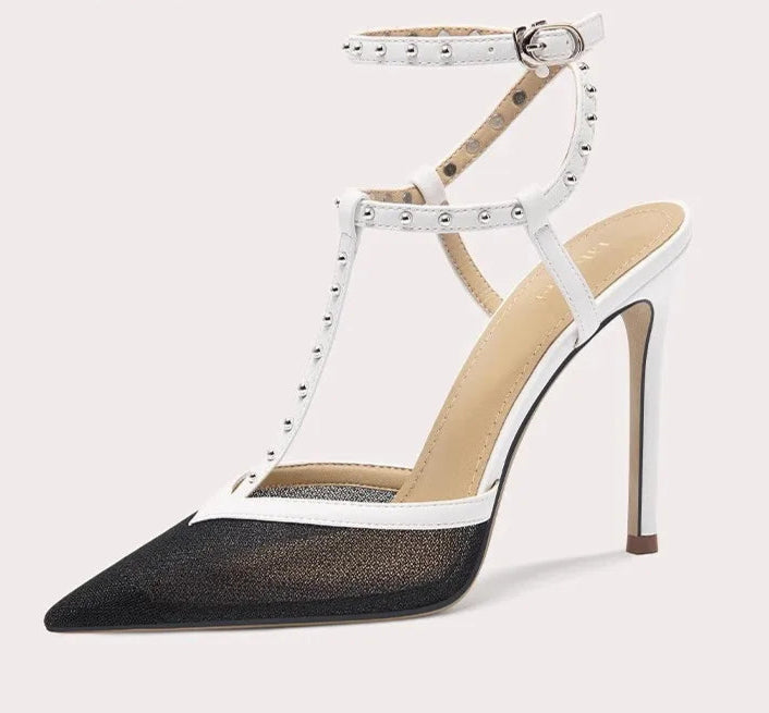 High-heeled shoe with white strap and black sole on a light gray background