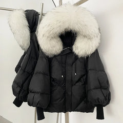 Black puffer jacket with large fur hood on a rack against a white background