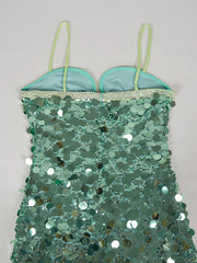 Green sequin dress with thin straps on a light gray background