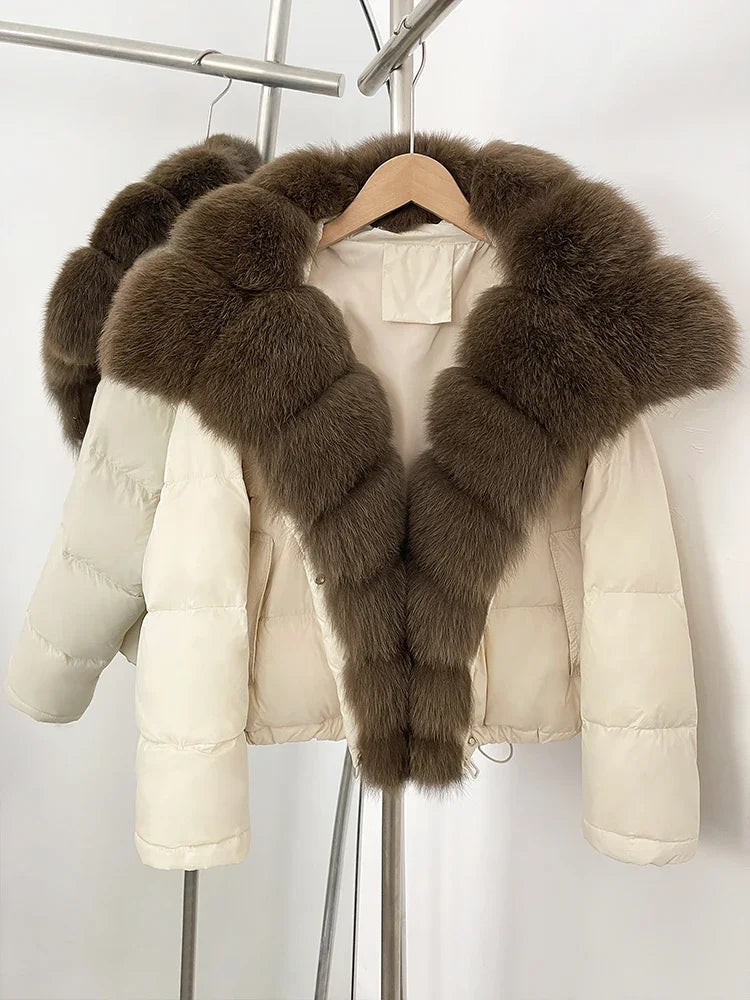 Beige puffer jacket with brown fur trim on a hanger against a white background
