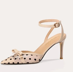 High-heeled shoe with polka dot pattern and bow detail on a white background