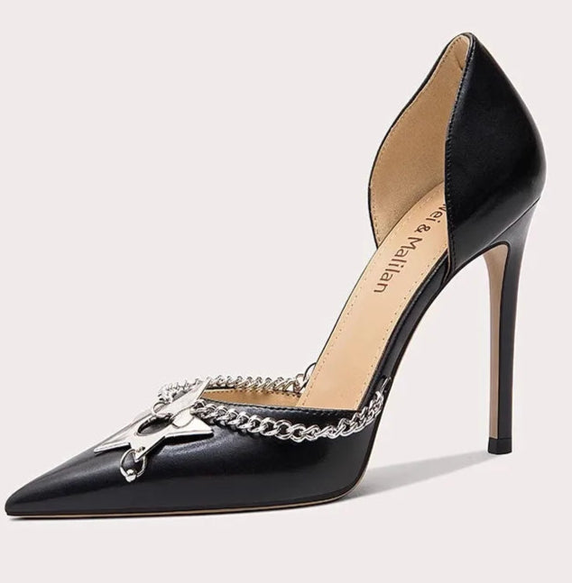 Black high-heeled shoe with chain detail on a light gray background