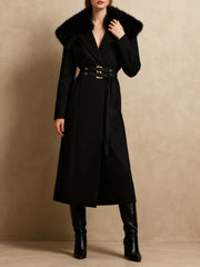 Black coat with fur collar worn by a model on a beige background