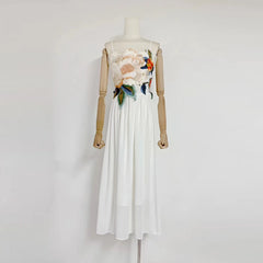 White dress with floral embroidery on a mannequin against a white background