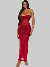 Woman wearing a red strapless dress with sheer overlay on a gray background