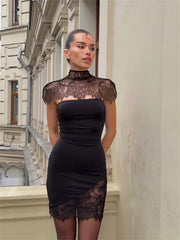 Woman wearing a black lace dress standing against an urban building background