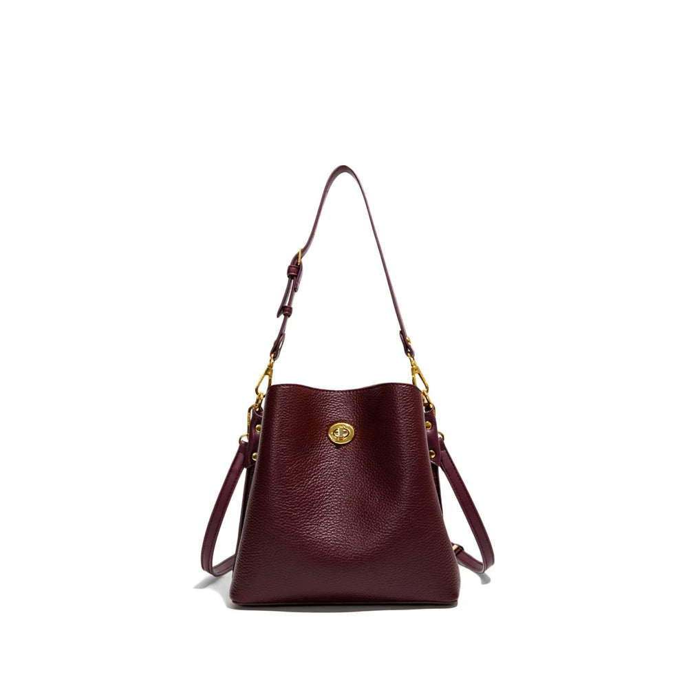 Brown leather handbag with gold accents on a white background