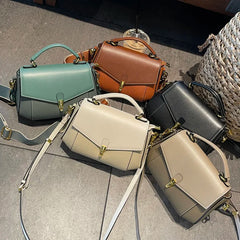 Collection of handbags in various colors on a textured surface