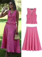 Woman wearing a pink dress with a matching top and skirt, standing outdoors.