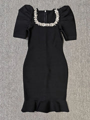 Black dress with floral embellishments on a gray background