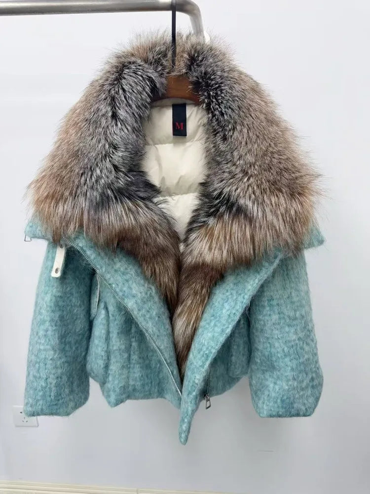 Teal coat with fur collar on a hanger against a white background