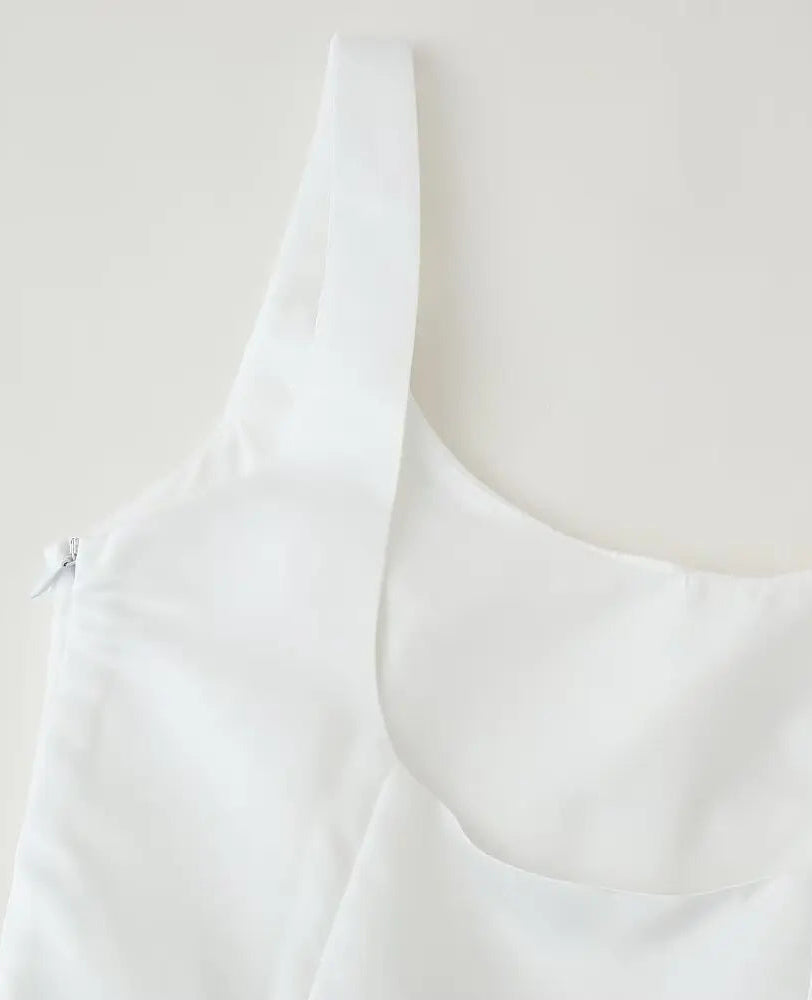 White sleeveless top on a mannequin against a plain background