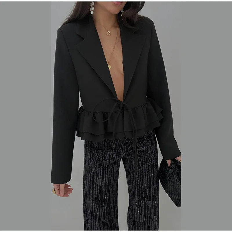 Fitted crop blazer featuring a cinched waist and soft ruffles