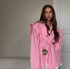 Woman wearing a pink coat with a neutral background