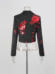 Black jacket with red floral embroidery on a mannequin against a gray background