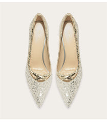 Pair of glittery gold high heels on a white background