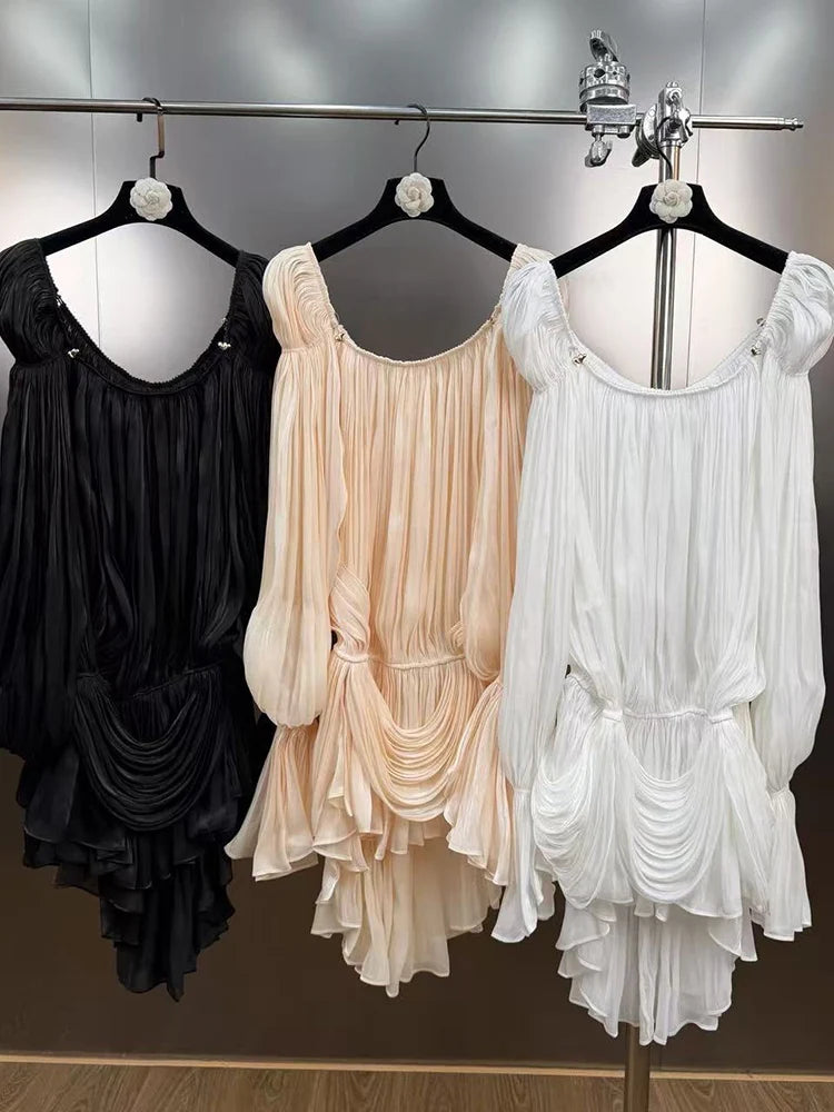 Three dresses in black, beige, and white hanging on a rack.