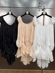 Three dresses in black, beige, and white hanging on a rack.
