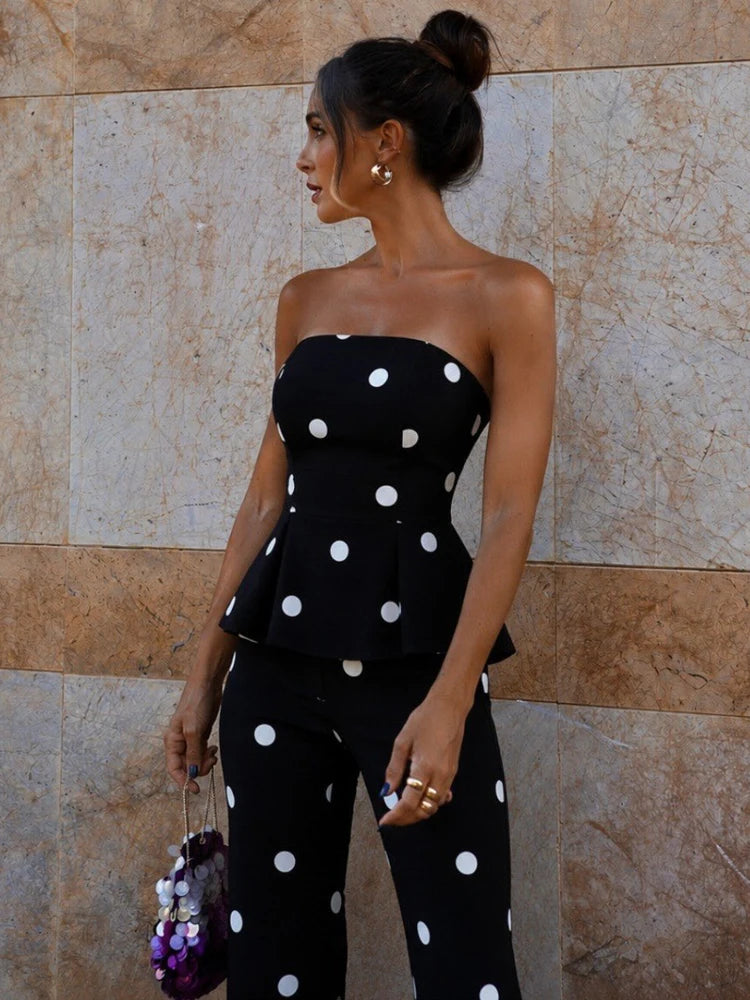 Model wearing black polka dot strapless peplum top and flare pants
