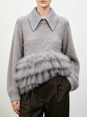 Gray knit sweater with a structured collar and a layered gray tulle ruffle detail at the waist.