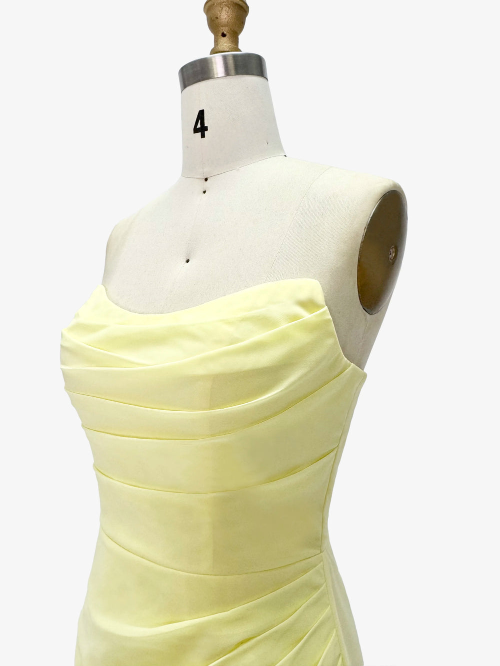 Light yellow dress on a mannequin with a white background
