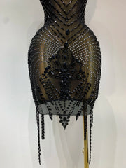 Black beaded dress on a mannequin against a white background