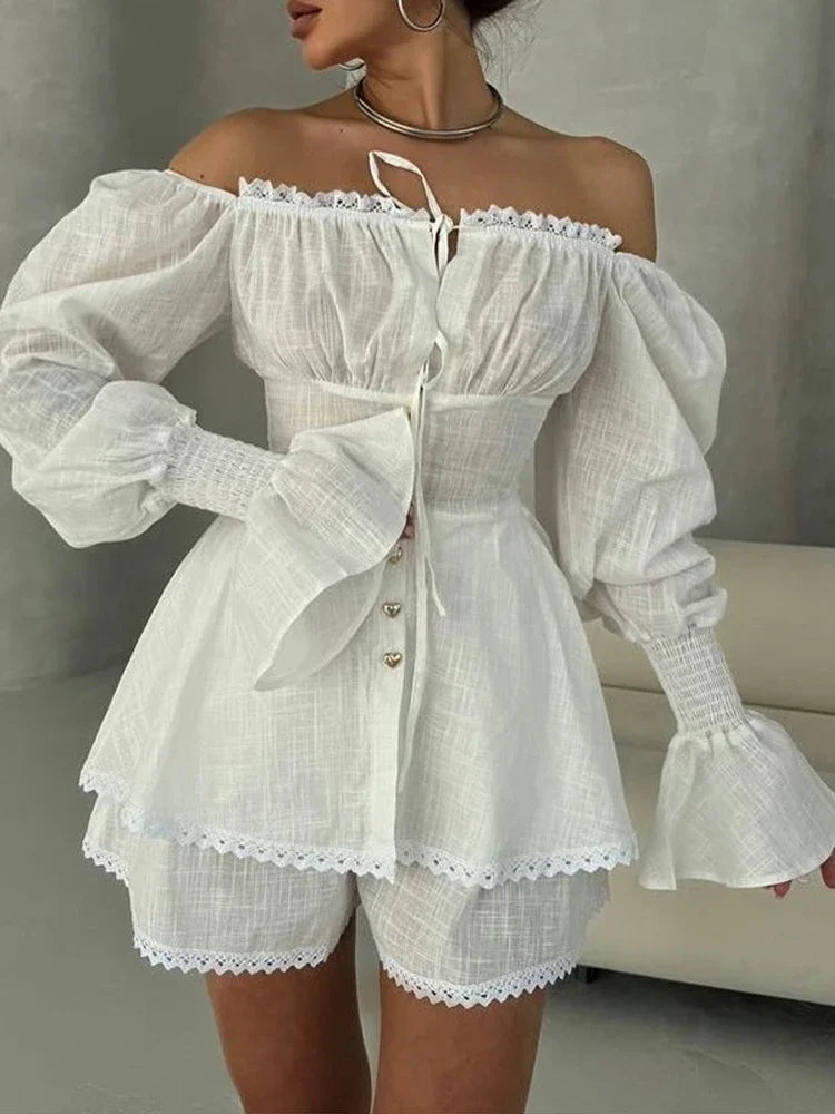 White off-shoulder dress with ruffled sleeves and hem on a neutral background