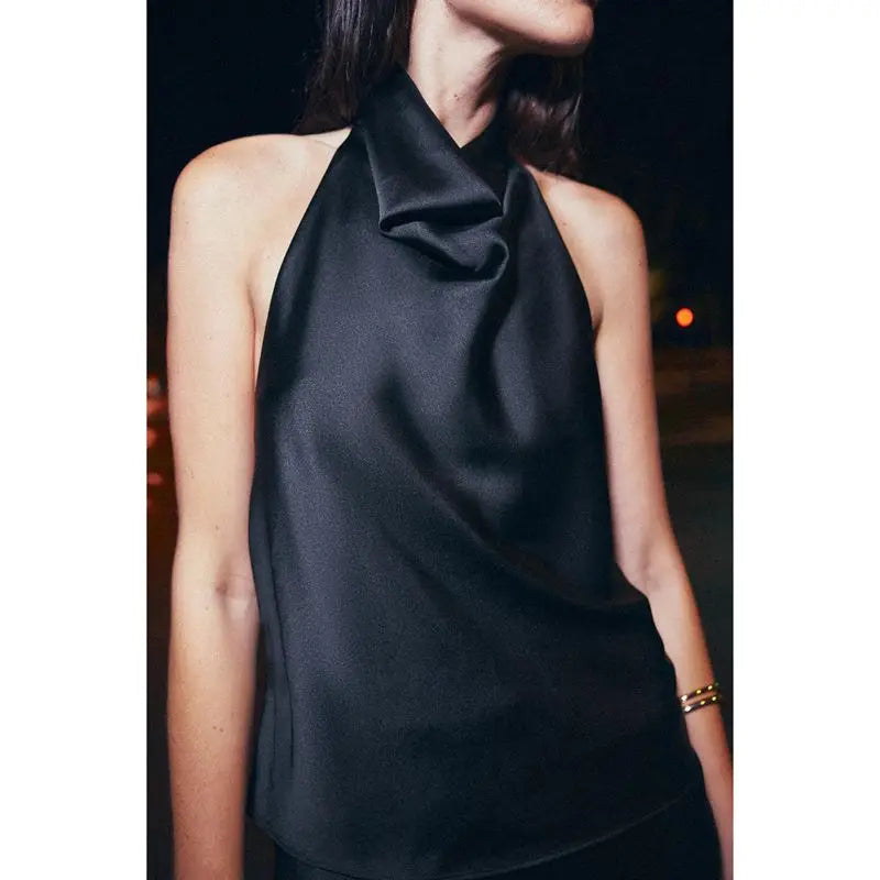 Black sleeveless top worn by a person with a blurred background