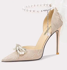 Beige high-heeled shoe with decorative bow on a white background