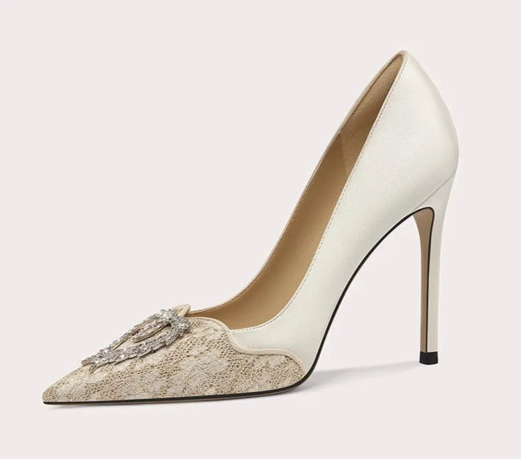 White high-heeled shoe with decorative element on a light gray background