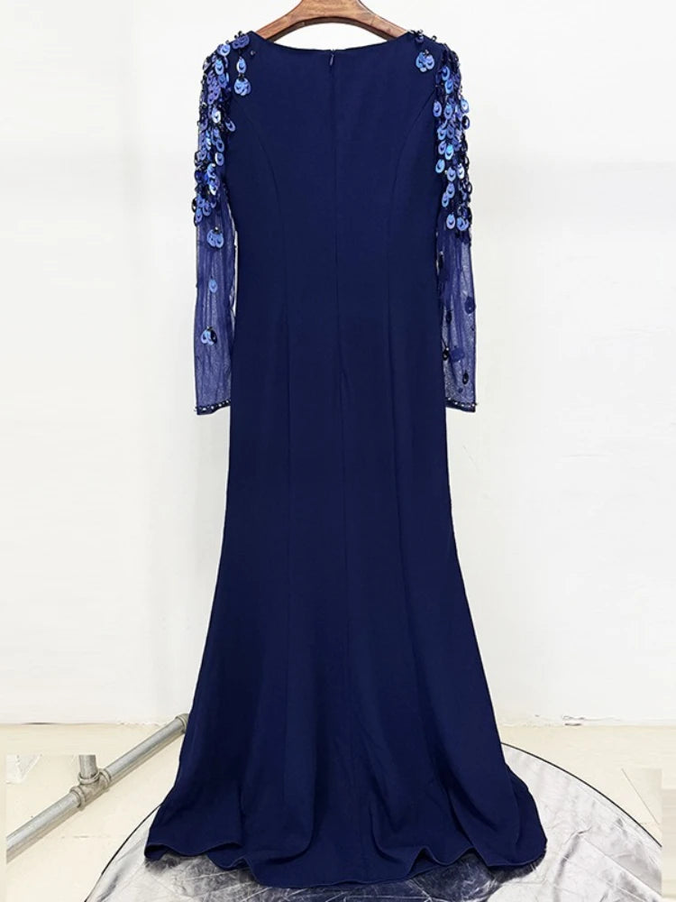 Navy blue evening gown with floral embellishments on a white background