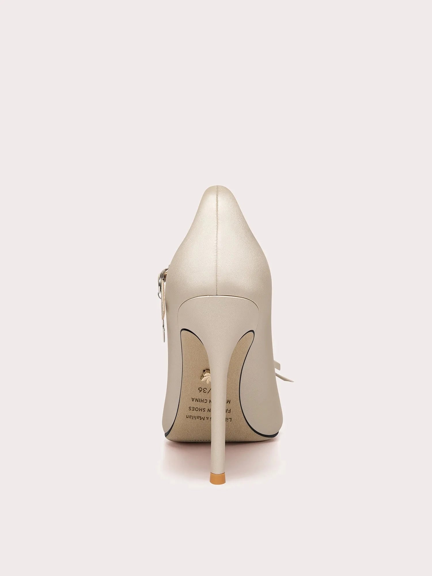 White high-heeled shoe on a light gray background