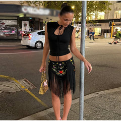 Woman wearing a black floral embroidered mini skirt with fringe