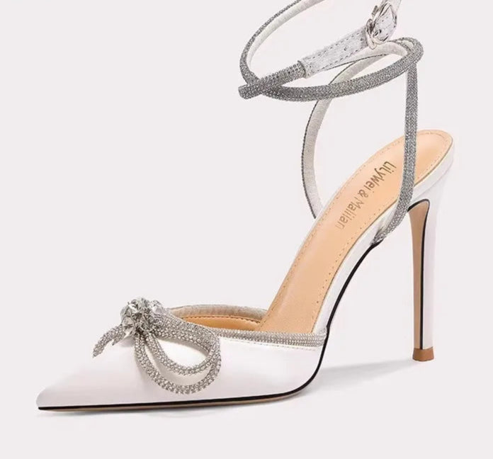 White high-heeled shoe with decorative bow on a white background