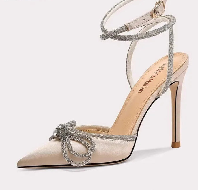 High-heeled shoe with decorative strap on a white background