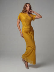 Woman wearing a gold dress against a gray background