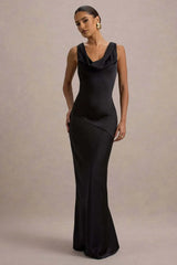Woman wearing a black evening gown against a neutral background