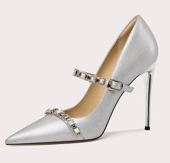 Silver high-heeled shoe with decorative strap on a light gray background