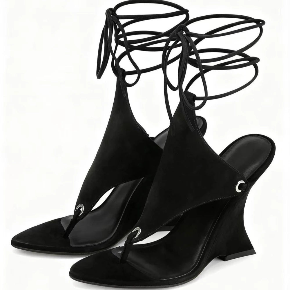 Black wedge sandals with lace-up design on a white background