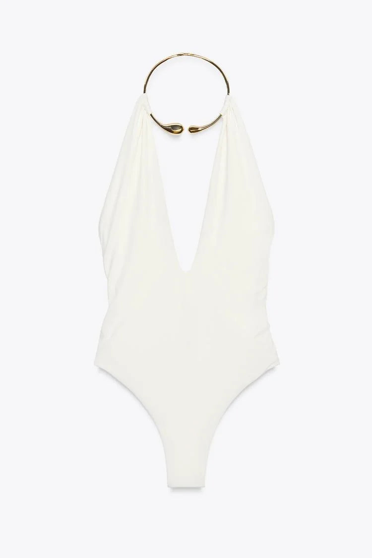 White swimsuit with gold ring detail on a white background