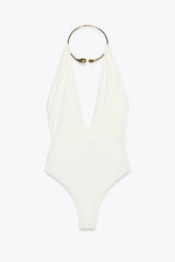 White swimsuit with gold ring detail on a white background