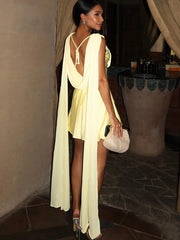 Model wearing a yellow sleeveless mini dress with draped scarf detail