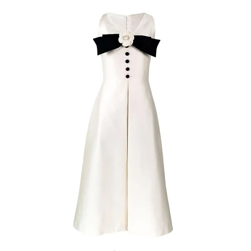 White dress with black bow and buttons on a white background