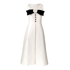 White dress with black bow and buttons on a white background