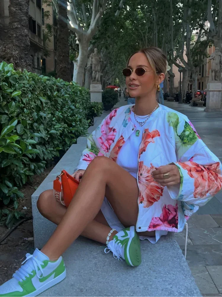 Person wearing a floral quilted bomber jacket and white shorts