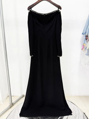 Back view of a black long sleeve maxi dress with beaded trim.