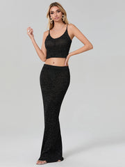 Woman wearing a black glittery two-piece outfit on a gray background