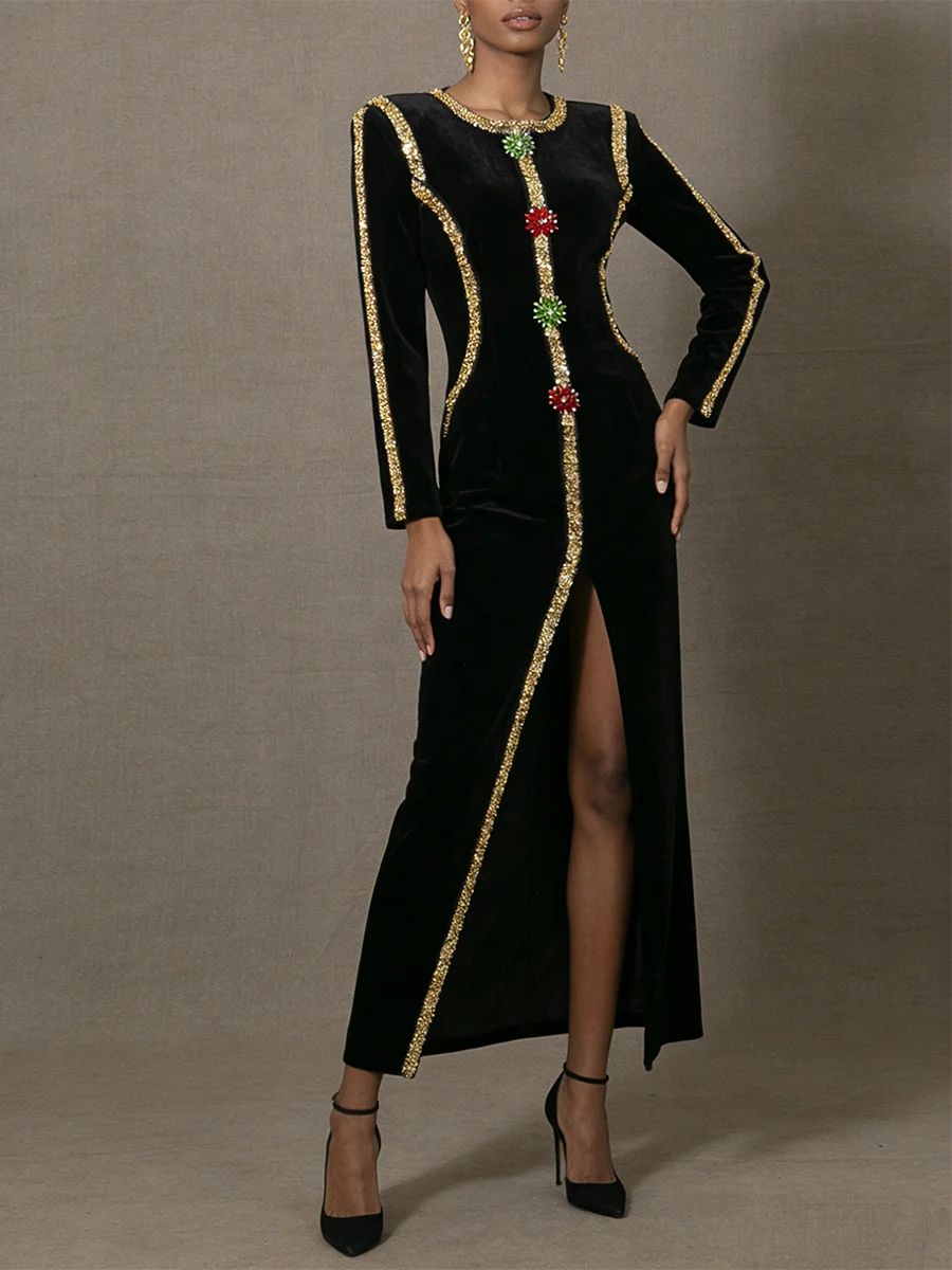 Black dress with gold trim and floral embellishments on a gray background